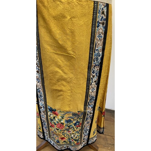 891 - A Chinese silk embroidered skirt, decorated flowers, on a yellow ground