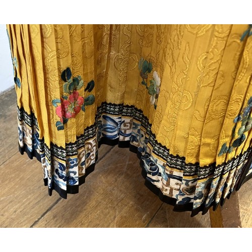 891 - A Chinese silk embroidered skirt, decorated flowers, on a yellow ground