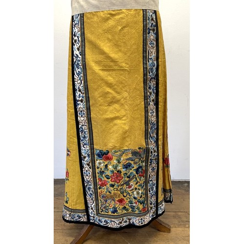 891 - A Chinese silk embroidered skirt, decorated flowers, on a yellow ground