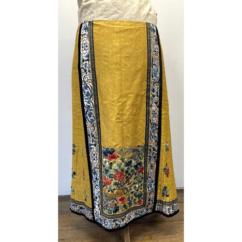 891 - A Chinese silk embroidered skirt, decorated flowers, on a yellow ground