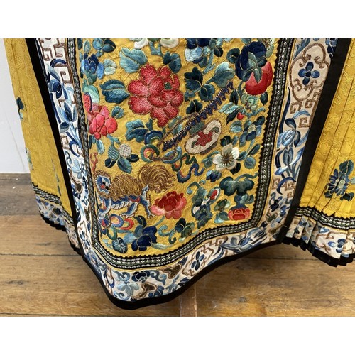 891 - A Chinese silk embroidered skirt, decorated flowers, on a yellow ground