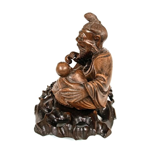 966 - A Chinese carving of a man with a pipe, 32 cm wide, on a pierced base