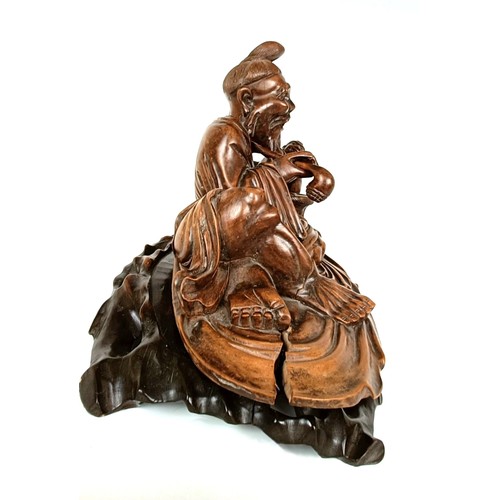 966 - A Chinese carving of a man with a pipe, 32 cm wide, on a pierced base