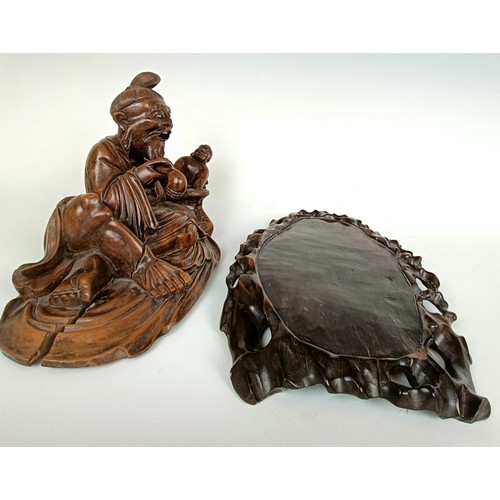 966 - A Chinese carving of a man with a pipe, 32 cm wide, on a pierced base