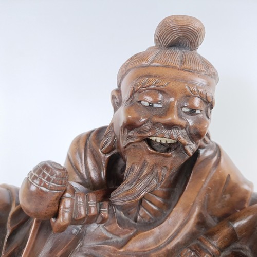 966 - A Chinese carving of a man with a pipe, 32 cm wide, on a pierced base