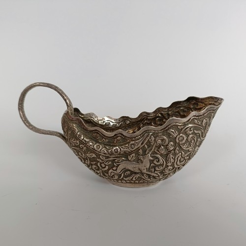 150 - A silver coloured metal sauce boat, with emobossed decoration