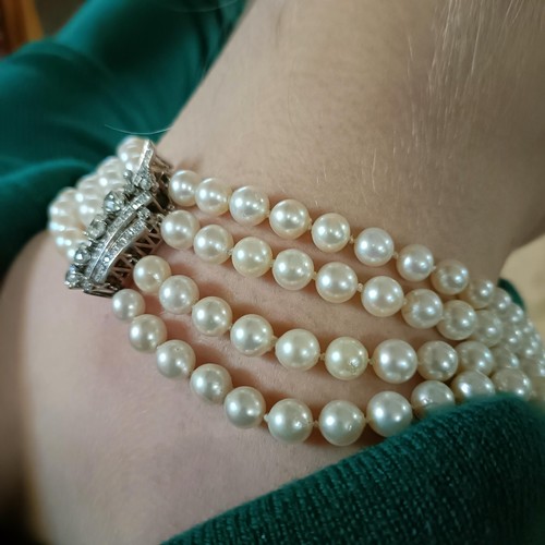 301 - A four strand cultured pearl necklace, with an impressive diamond clasp, the largest diamond approx.... 