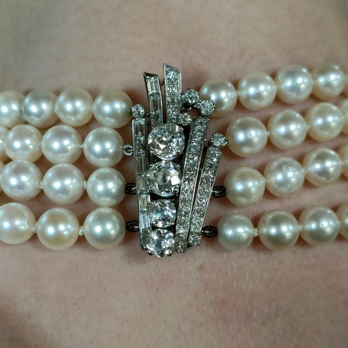 301 - A four strand cultured pearl necklace, with an impressive diamond clasp, the largest diamond approx.... 