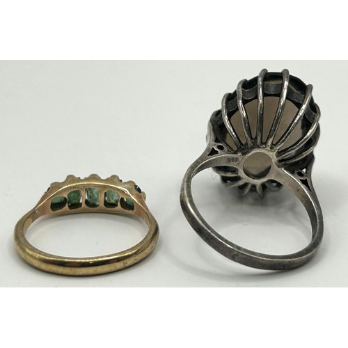 324 - A 9ct gold and green stone ring, ring size J, and a brown stone dress ring, ring size N (2)