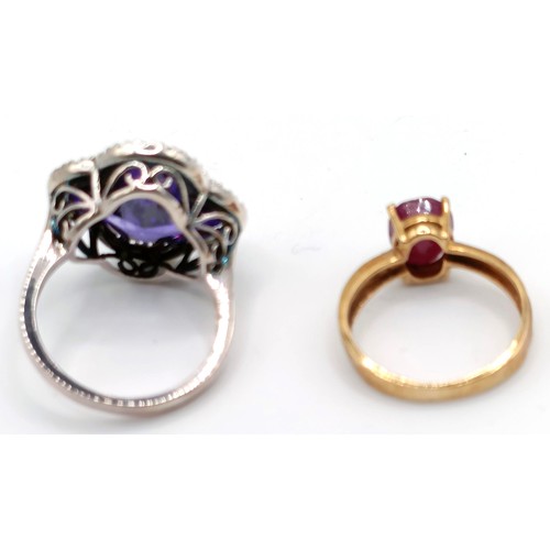 348 - A 10ct gold and red stone ring, ring size G, and a silver and purple stone ring, ring size K (2)