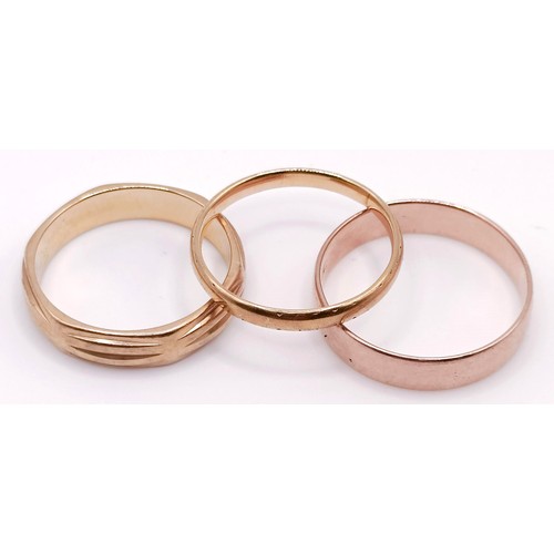 402 - A 9ct gold wedding band, and two other wedding bands (3)