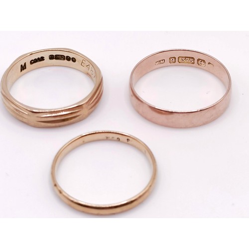 402 - A 9ct gold wedding band, and two other wedding bands (3)