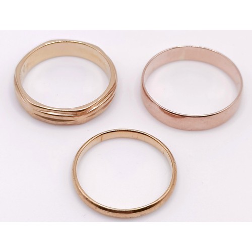 402 - A 9ct gold wedding band, and two other wedding bands (3)