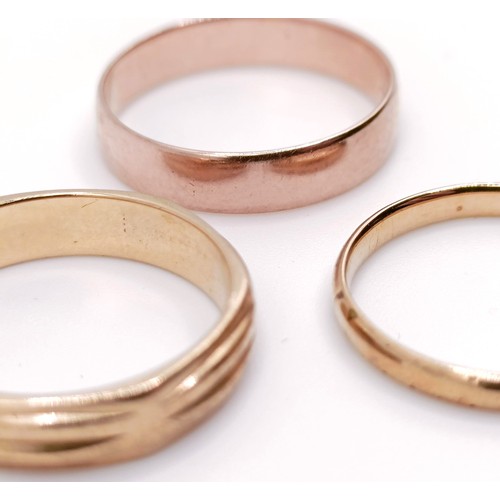 402 - A 9ct gold wedding band, and two other wedding bands (3)