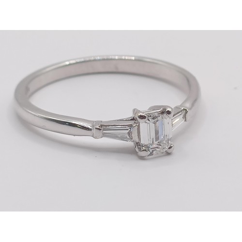 427 - An 18ct white gold and solitaire emerald cut diamond ring, ring size N