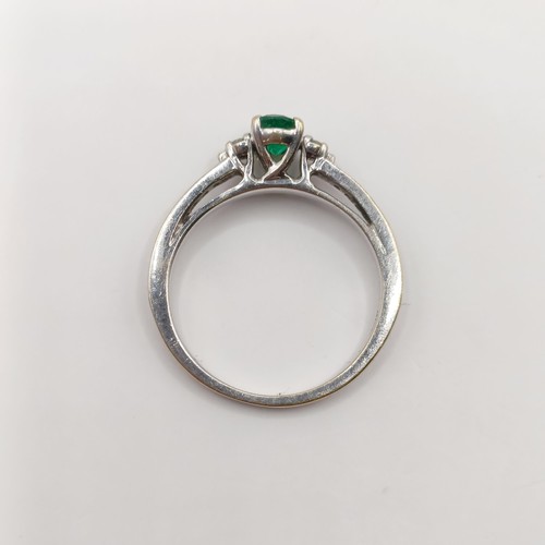 438 - An 18ct white gold, emerald and diamond ring, ring size J