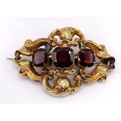 488 - A late 19th century yellow coloured metal and red stone brooch, in a vintage jewellery box