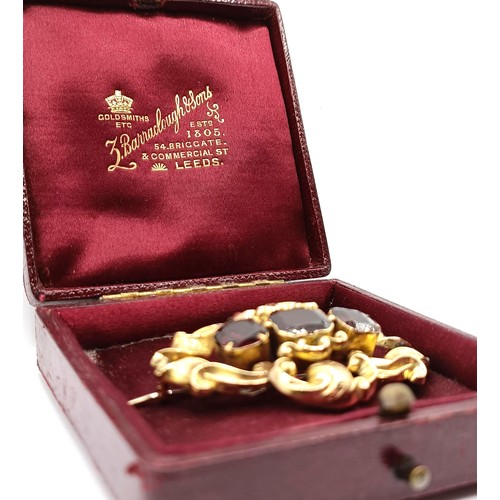 488 - A late 19th century yellow coloured metal and red stone brooch, in a vintage jewellery box