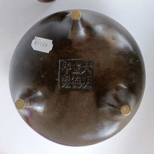 801 - A Chinese bronze tripod censer, character mark to base, 23 cm diameter, on a carved hardwood base (2... 