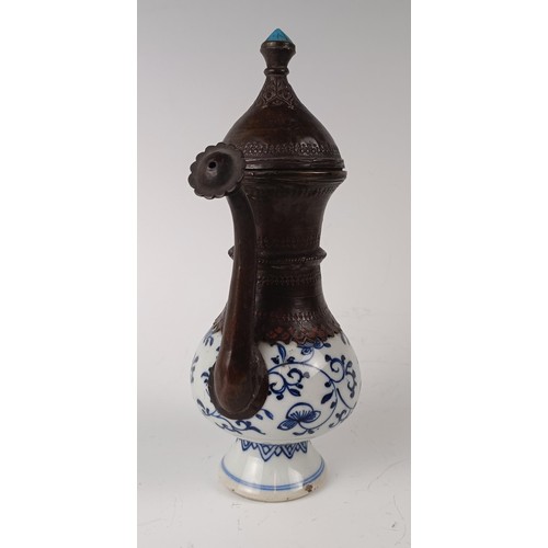 993 - A Moorish style ewer, the porcelain body decorated in underglaze blue and with metal mounts, 21 cm h... 