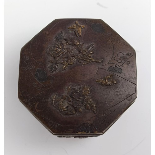 1001 - A Japanese bronze octagonal box, decorated butterflies and flowers, lacking base, 6.5 cm wide...