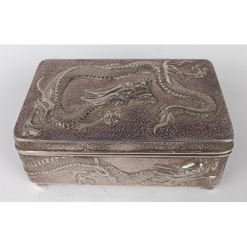 1010 - A Chinese silver coloured metal rectangular box, decorated a dragon, 12 cm wide...