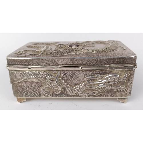 1010 - A Chinese silver coloured metal rectangular box, decorated a dragon, 12 cm wide...