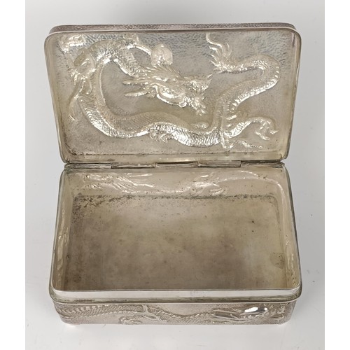 1010 - A Chinese silver coloured metal rectangular box, decorated a dragon, 12 cm wide