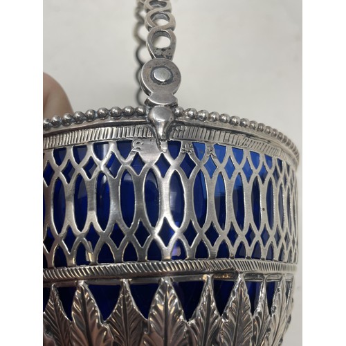 217 - An early 19th century silver swing handle basket, marks rubbed, 4.4 ozt, with a blue glass liner