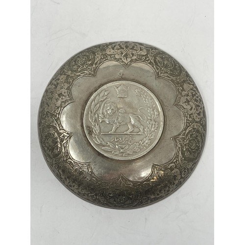 187 - An Iranian silver coloured metal dish, inset with coin, 62.5 g