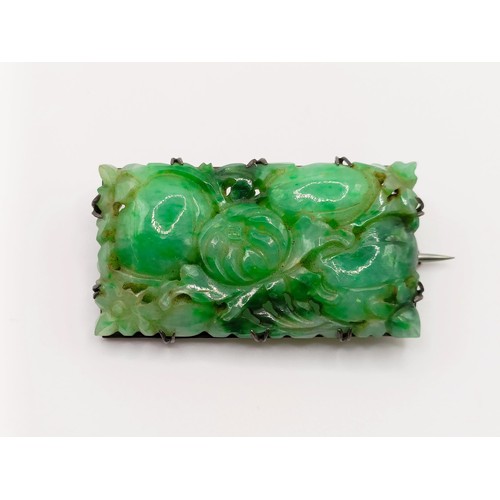 467 - A 1920s carved jadeite plaque brooch, decorated flowers