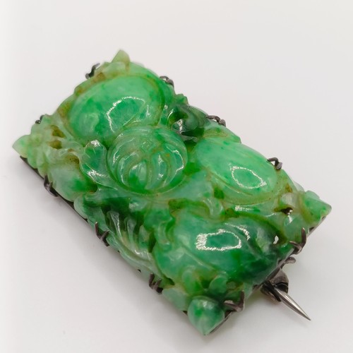 467 - A 1920s carved jadeite plaque brooch, decorated flowers