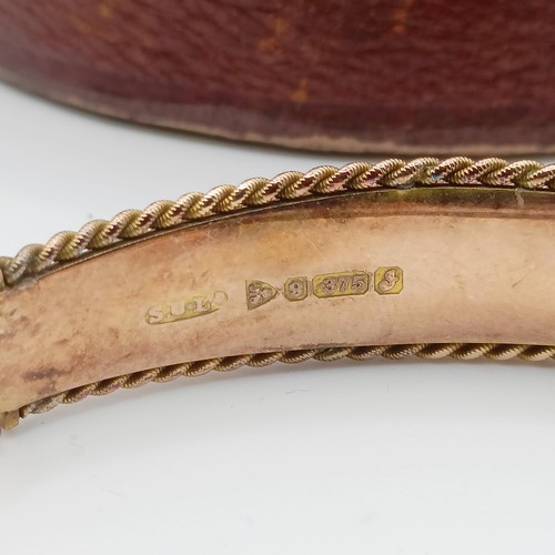 482 - An early 20th century yellow coloured metal, red and white stone bangle, in a vintage jewellery box