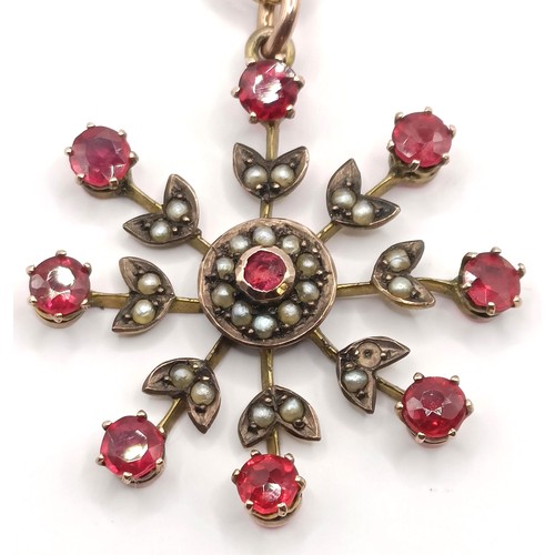 628 - A yellow metal, red stone and seed pearl floral brooch, on a chain