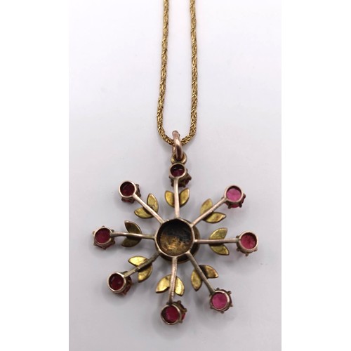 628 - A yellow metal, red stone and seed pearl floral brooch, on a chain