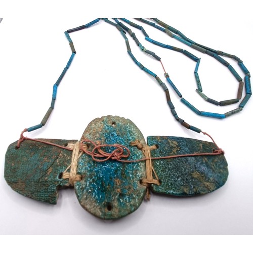 572 - An Egyptian turquoise faience winged scarab pendant, on a turquoise necklace, 12 cm wide