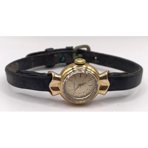 584 - A ladies 9ct gold Omega wristwatch, with a leather strap, in a vintage jewellery box