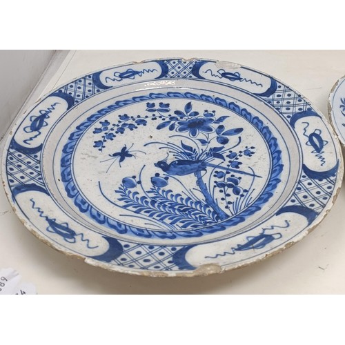 1101 - A blue and white Delft plate, decorated birds and flowers, 35 cm diameter, and another, decorated in...