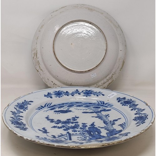 1101 - A blue and white Delft plate, decorated birds and flowers, 35 cm diameter, and another, decorated in...