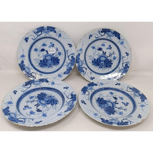 1104 - A set of four blue and white Delft plates, decorated flowers, 23 cm diameter...