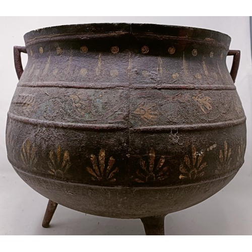 1128 - A cast iron cauldron, with painted decoration, 42 cm wide