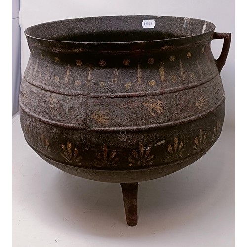 1128 - A cast iron cauldron, with painted decoration, 42 cm wide...