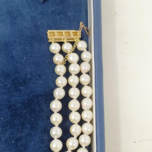 531 - A pearl triple strand necklace, with a 9ct gold clasp, by Coleman Douglas, cased