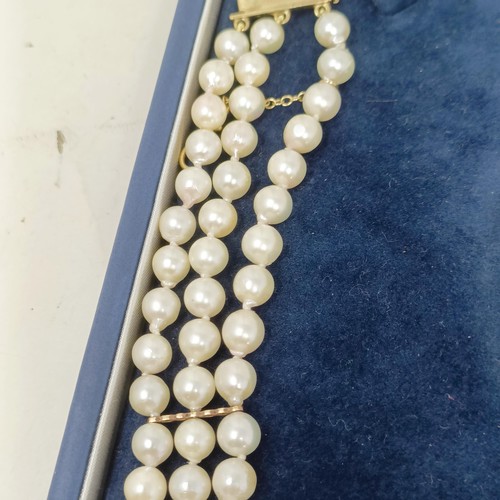 531 - A pearl triple strand necklace, with a 9ct gold clasp, by Coleman Douglas, cased