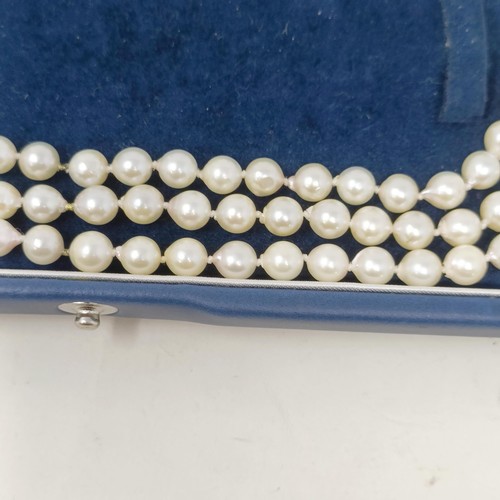 531 - A pearl triple strand necklace, with a 9ct gold clasp, by Coleman Douglas, cased