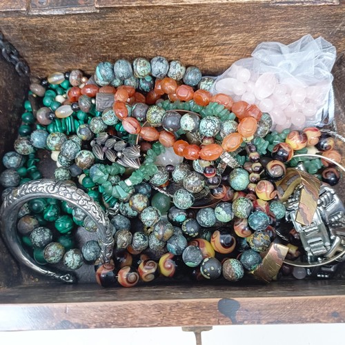 533 - A large brass bound wooden casket of semi-precious beads, including rose quartz, jade, malachite and... 