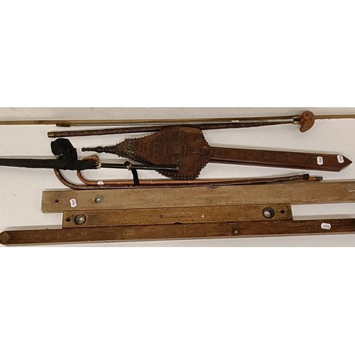 1182 - A folding measure, two spirit levels, a carved set of bellows and assorted walking sticks