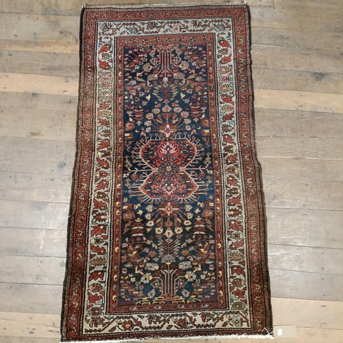 1287 - A Persian red ground rug, 200 x 112 cm