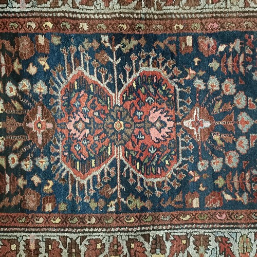 1287 - A Persian red ground rug, 200 x 112 cm