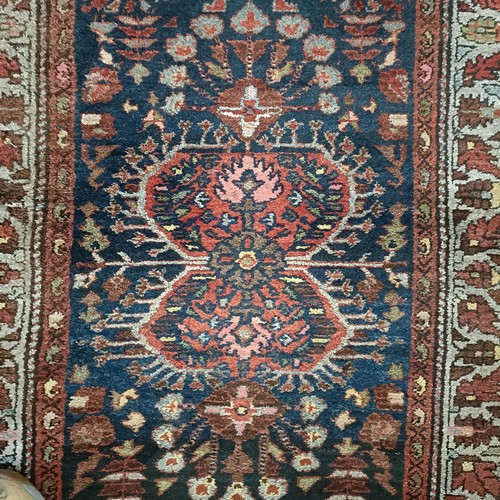 1287 - A Persian red ground rug, 200 x 112 cm